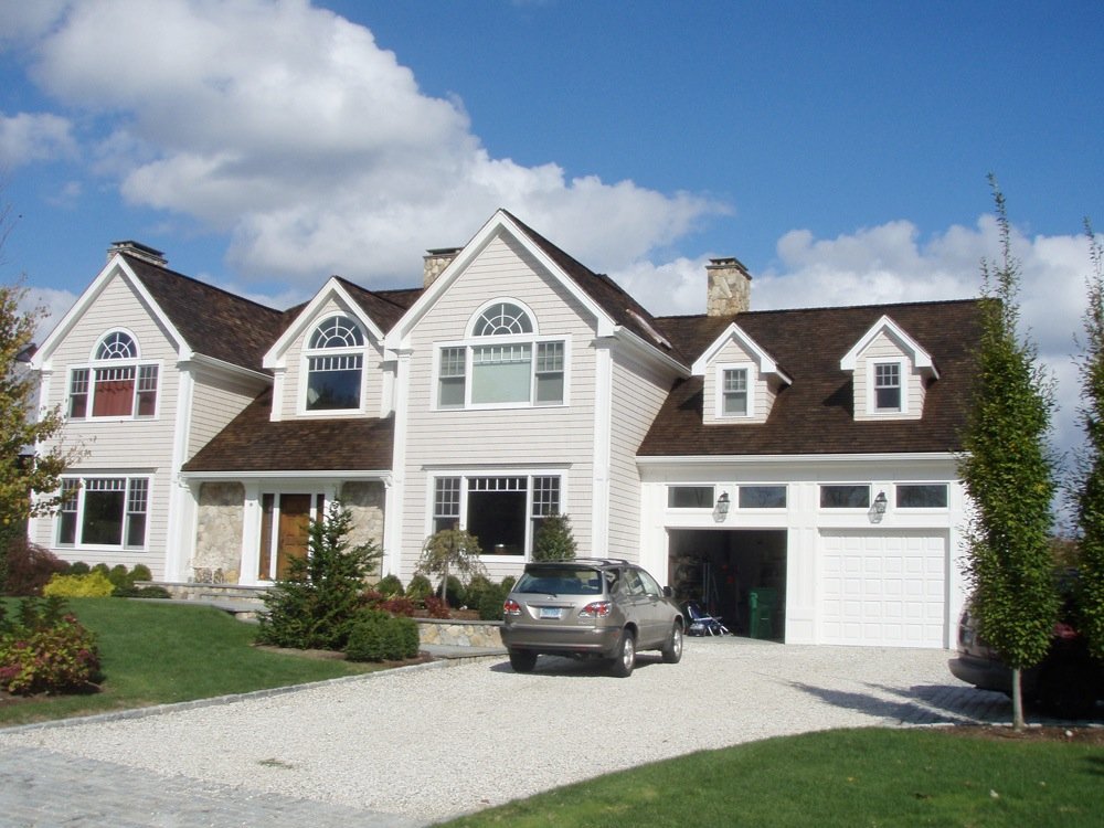 Completed dark shingle roof on a white traditional residence