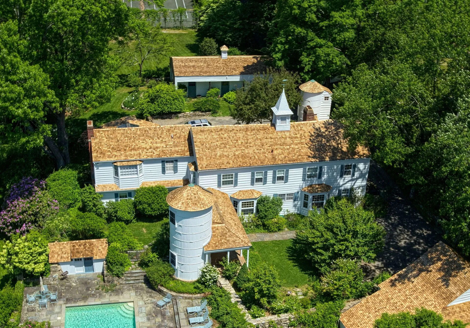 Aerial view of a detailed cedar roof with cupolas and multiple rooflines
