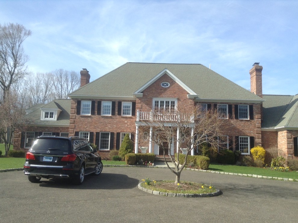 Front driveway view of a large traditional home and its rooflines