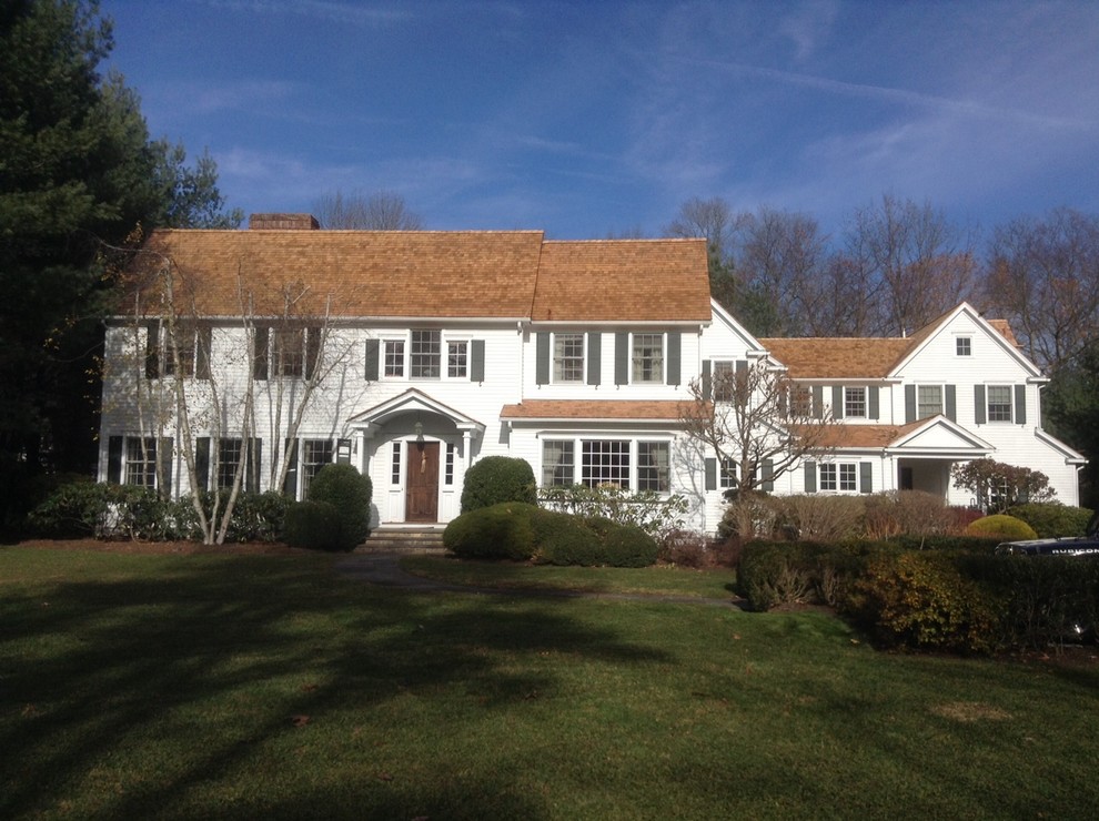 Traditional white residence with a warm cedar roof